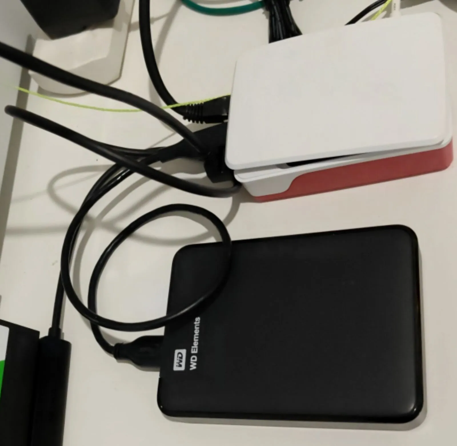 A Raspberry Pi 5 in its white and red case, and below it a black WD Elements 2 TB USB disk plugged into it